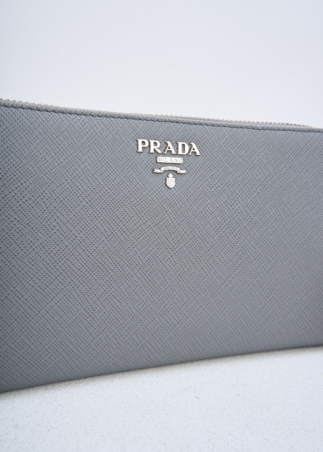 Prada, Grey leather wallet, QWA_SAFFIANO_METAL_1ML506_F0K44_MARMO, Grey, Detail, This grey Saffiano leather wallet has the brand's silver-tone metal logo on the front. The silver-tone zipper opens up to three bill compartments and a zipper coin pocket. The wallet has multiple card-slots. 