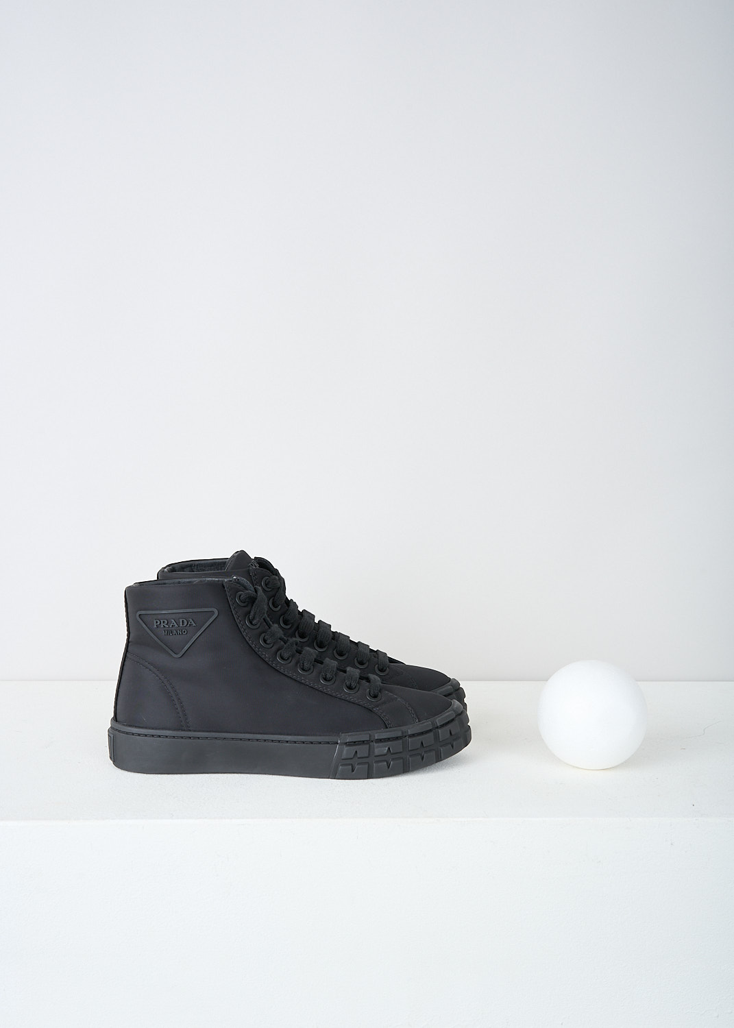 Prada, Black high top sneakers, 1T498M_1YFL_F0002, Black, Side, These high top black nylon sneakers feature a front lace-up fastening with black laces. These sneakers have a round toe. The brand's logo can be found embossed on the tongue. The brand's triangle logo can be found on the side. 
