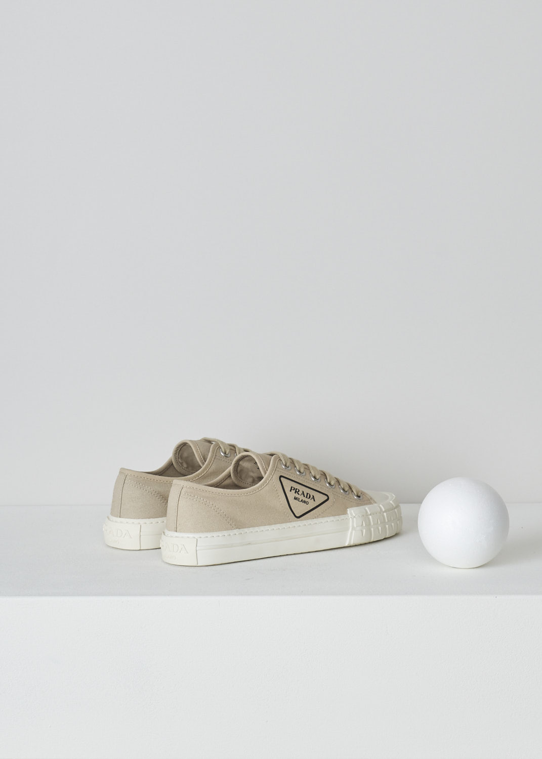 PRADA, BEIGE LOW TOP CANVAS SNEAKERS, 1E231M_2OFZ_F0065_CORDA, Beige, Back, These low top beige canvas sneakers feature a front lace-up fastening with laces in the same beige color. The brand's triangle logo can be found on the side in black rubber. These sneakers have a round toe with a white rubber toe cap and ribbed rubber soles. 
