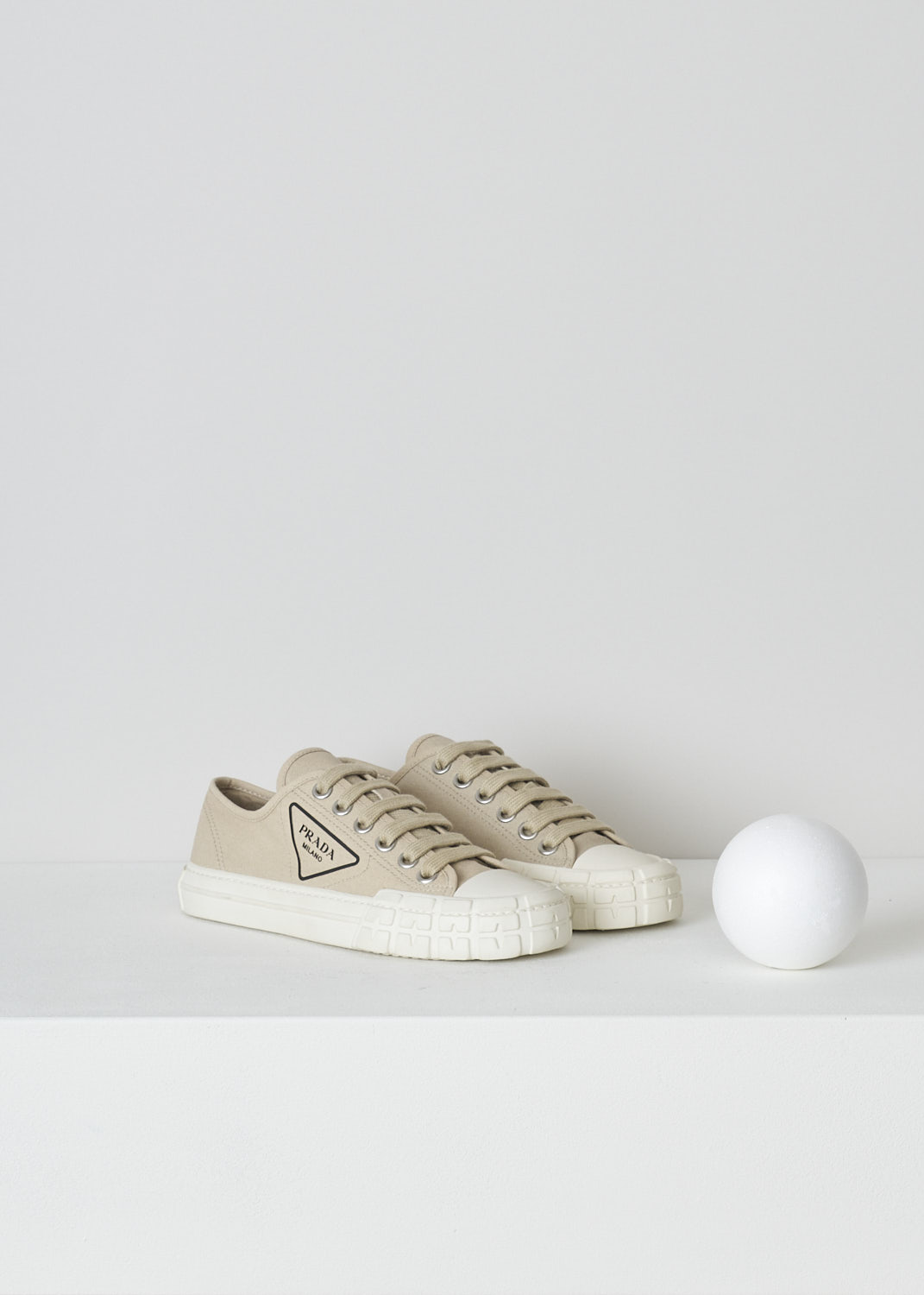 PRADA, BEIGE LOW TOP CANVAS SNEAKERS, 1E231M_2OFZ_F0065_CORDA, Beige, Front, These low top beige canvas sneakers feature a front lace-up fastening with laces in the same beige color. The brand's triangle logo can be found on the side in black rubber. These sneakers have a round toe with a white rubber toe cap and ribbed rubber soles. 

