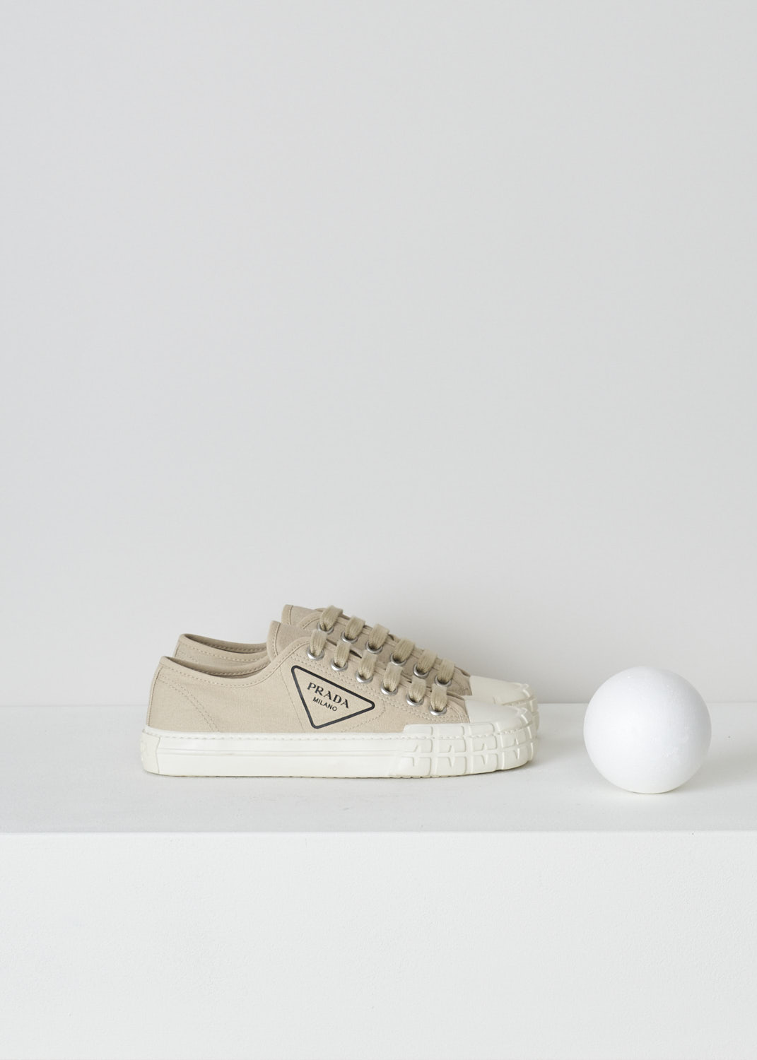 PRADA, BEIGE LOW TOP CANVAS SNEAKERS, 1E231M_2OFZ_F0065_CORDA, Beige, Side, These low top beige canvas sneakers feature a front lace-up fastening with laces in the same beige color. The brand's triangle logo can be found on the side in black rubber. These sneakers have a round toe with a white rubber toe cap and ribbed rubber soles. 
