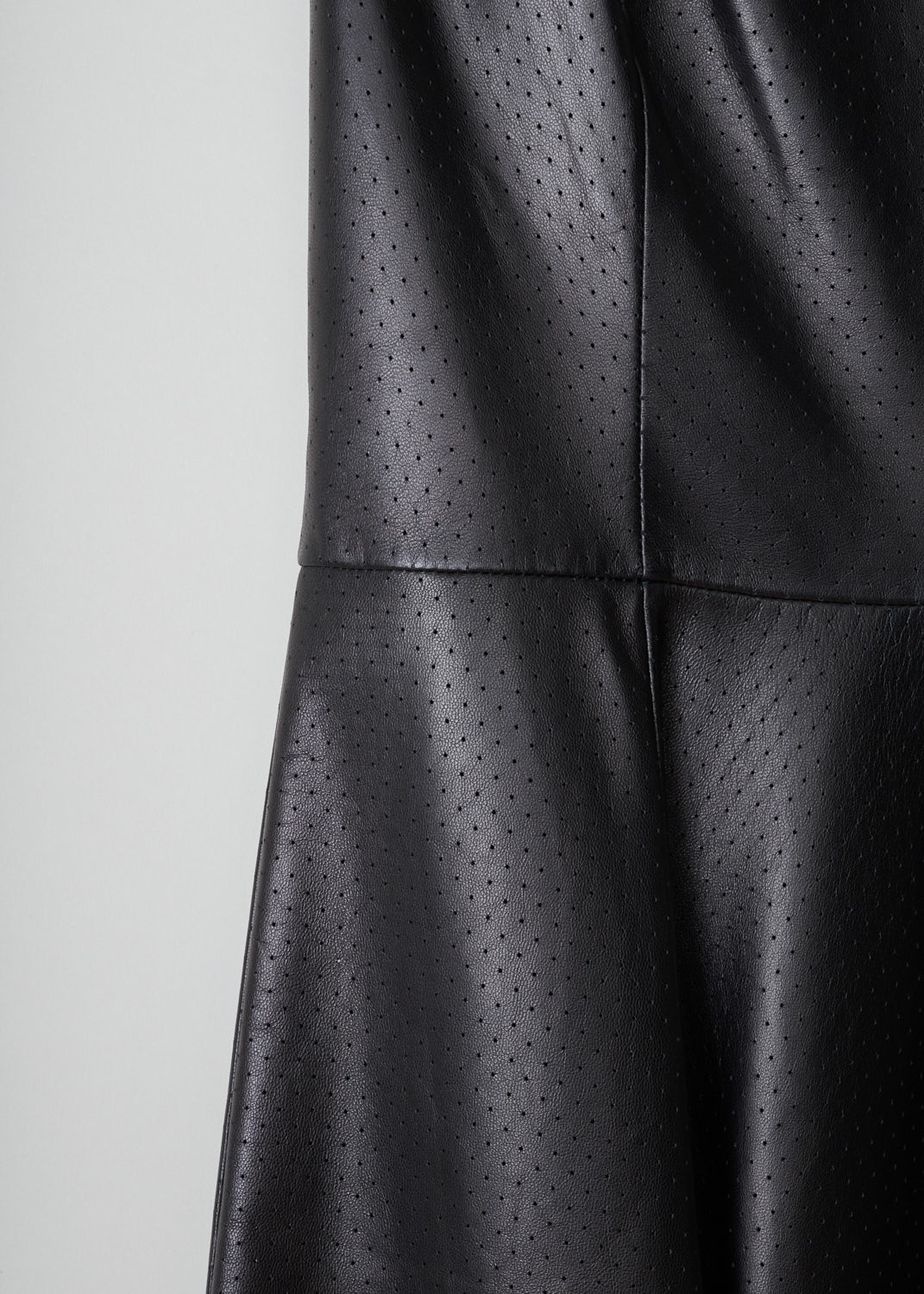 Prada, Perforated black leather dress, nappa_53279_F0002_nero, black, detail, Black leather is perforated to get this special look. the dress is modeled after a princess dress and has a pleated skirt. Furthermore it has a round neckline without sleeves. A concealed zipper can be found in the side seam.