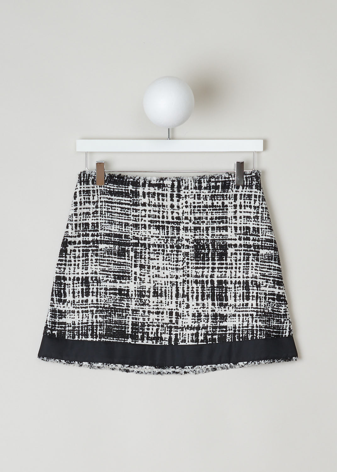 PRADA, BLACK AND WHITE TWEED MINI SKIRT, P164T_F0A72_03_TELONE_TWEED_RE_AVORIO_NERO, Black, White, Print, Front, This black and white tweed mini skirt has a concealed zip closure in the side seam. The skirt has a broad black trim along the hemline. In the back, the skirt has a single welt pocket with a black trim with underneath a black and silver logo plaque. The skirt is fully lined. 
