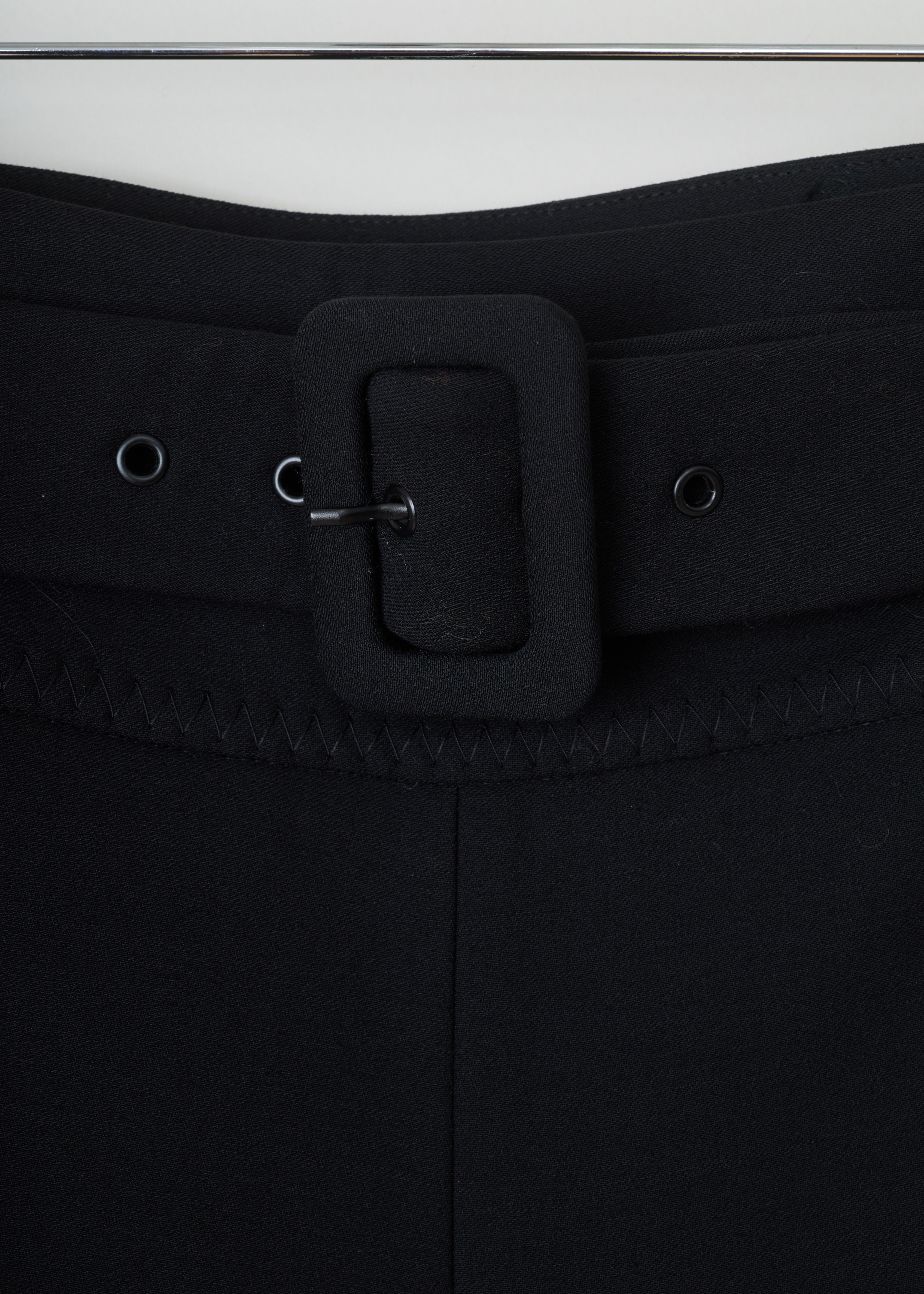 Prada Black belted trousers Natte_Double_Im_P271BH_F0002_Nero detail. Fitted black trousers with a wide waistband with belt loops and a detachable belt in the same fabric, an invisible zipper fastening on the side, centre creases and cuffed hems.