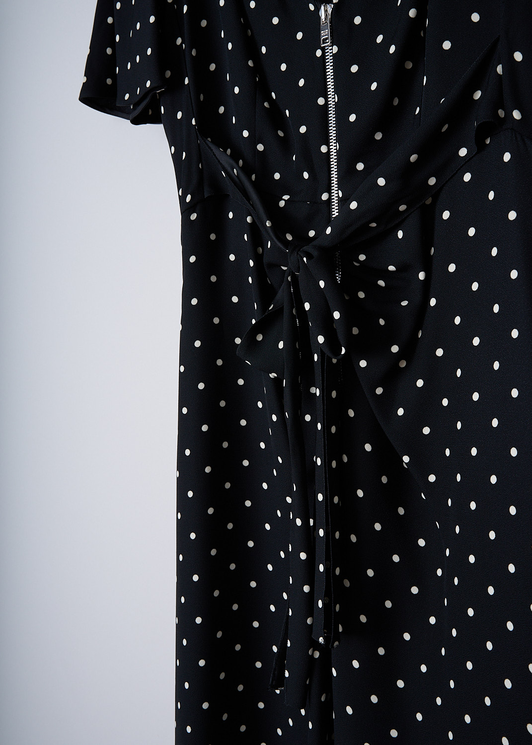 PRADA, BLACK MIDI DRESS WITH WHITE POLKA DOT PRINT, SABLE_POIS_ABITO_P3D14_1YH2_F057Z,  Black, White, Print, Detail, This short sleeve midi dress has a black base color with a small white polka dot print. The dress has a V-neckline. In the front, a two-way zip runs down the length of the dress with gathered pleats along the zipper. Below the buste, two ties can be used to cinch in the dress. The dress has a straight hemline.
