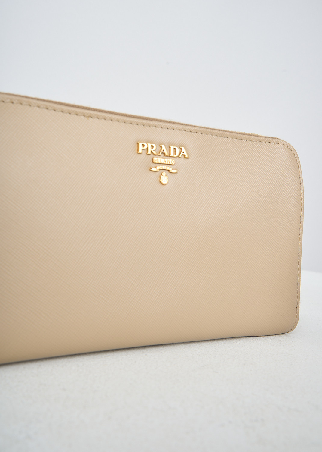 Prada, Sand beige leather wallet, QWA_SAFFIANO_METAL_1M0506_F0036_SABBIA, Beige, Detail, This sand beige Saffiano leather wallet has the brand's gold-tone metal logo on the front. The gold-tone zipper opens up to two bill compartments that are divided by the zipped coin pocket. The wallet has multiple card-slots.

