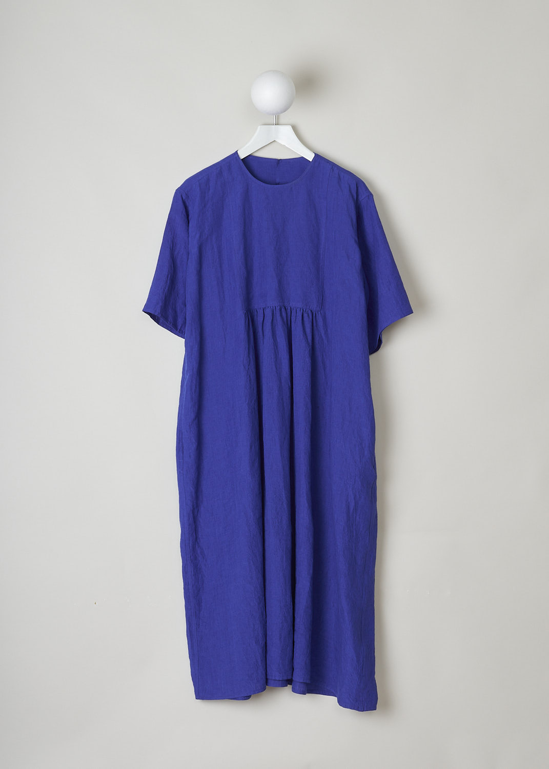 SOFIE D’HOORE, ROYAL BLUE LINEN DARNELLE DRESS, DARNELLE_LIFE_TOUAREG, Blue, Front, This oversized royal blue midi dress features a round neckline, dropped shoulders and short sleeves. The A-line dress has a square bib-like front with pleated details below. Concealed in the side seams, slanted pockets can be found. The dress has a straight hemline with slits on either side. 

