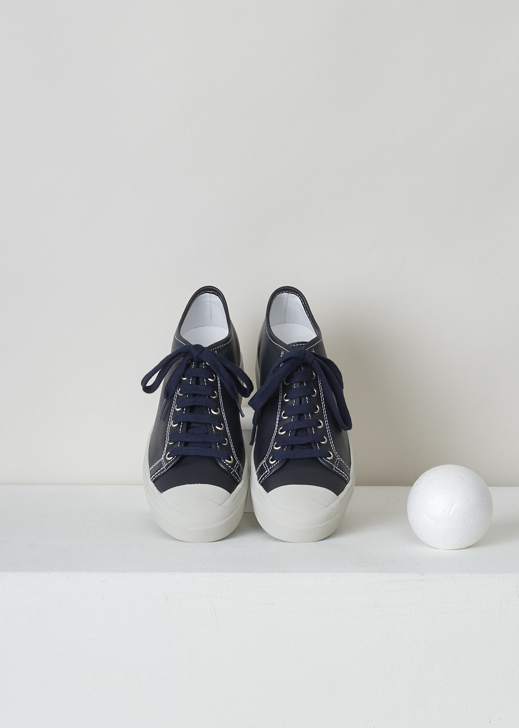 SOFIE D’HOORE, MIDNIGHT BLUE LEATHER SHOES, FOLK_LMAST_LMAST_MIDNIGHT, Blue, Top, These midnight blue leather sneakers feature a front lace-up closure with dark blue laces. These sneakers have a round toe with a white rubber toe cap that goes down into the white rubber sole. Contrasting white stitching is used throughout. The sneakers come with additional pair of white laces.
