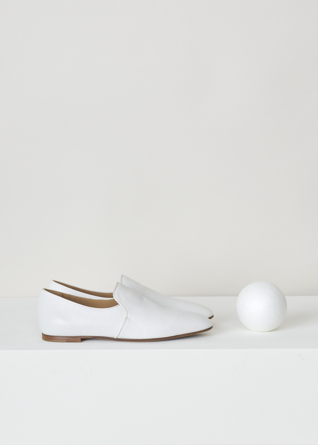 The Row, White leather alys slipper, F1005_L64_WHT, white, side, Made from a minimalist perspective, and crafted out of butter-soft calfskin. Featuring a rounded toe vamp and comes with white satin piping on the topline. The seamless lining ensures they can be worn with or without socks.
