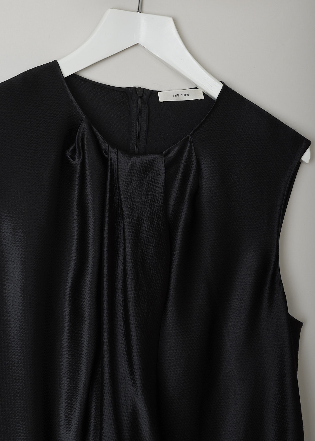 THE ROW, HAMMERED SATIN TOP IN BLACK, SHIRA_TOP_4923WI_616_BLACK,  Black, Detail, This hammered satin sleeveless top in black has a round neckline with a pleated front detailing. In the back, a concealed centre zip can be found. The top has a wider silhouette.
