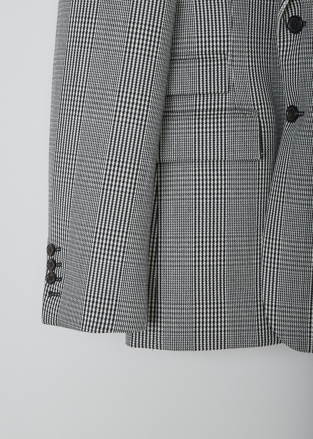 THOM BROWNE, BLACK AND WHITE PRINCE DE GALLES CHECK SPORT JACKET, FBC681A_06298_980, Black, White, Print, Detail, This single-breasted sport jacket has a black and white prince de galles check motif. The jacket has a notched lapel, a front button closure and a nipped waist. The long sleeves have buttoned cuffs. In the front, the jacket has a single breast pocket and two flap welt pockets. On the inside, the jacket has a striped lining, three inner pockets and a name tag. The brand's signature grosgrain loop tab can be found in the back. The jacket has a double vent. 
  
