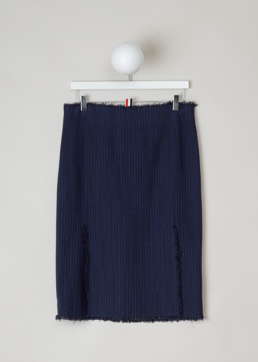 Thom Browne, Blue knitted pencil skirt, FGC452T_04529_415_navy, blue, back. Starting from the top this lovely pencil skirt has raw frilled edges. Zipper on the side for fastening. Also the hem is similarly unfinished and has frills hanging off. On the back this model has two splits.