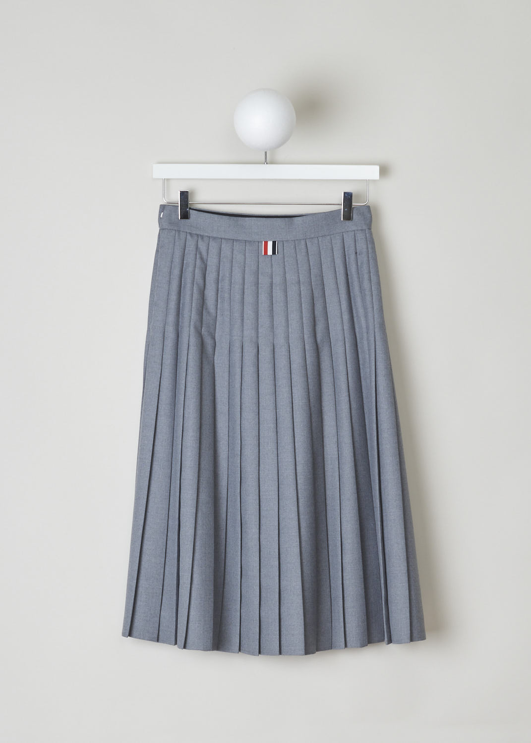 THOM BROWNE, BELOW THE KNEE GREY PLEATED SKIRT, FGC513A_02055_035_MED_GREY, Grey, Back, Grey pleated skirt reminiscent of a school uniform. This circle skirt has knife pleats throughout. It has a concealed zip and clasp on the side seam. In the back, the grosgrain pull tab can be found. 
