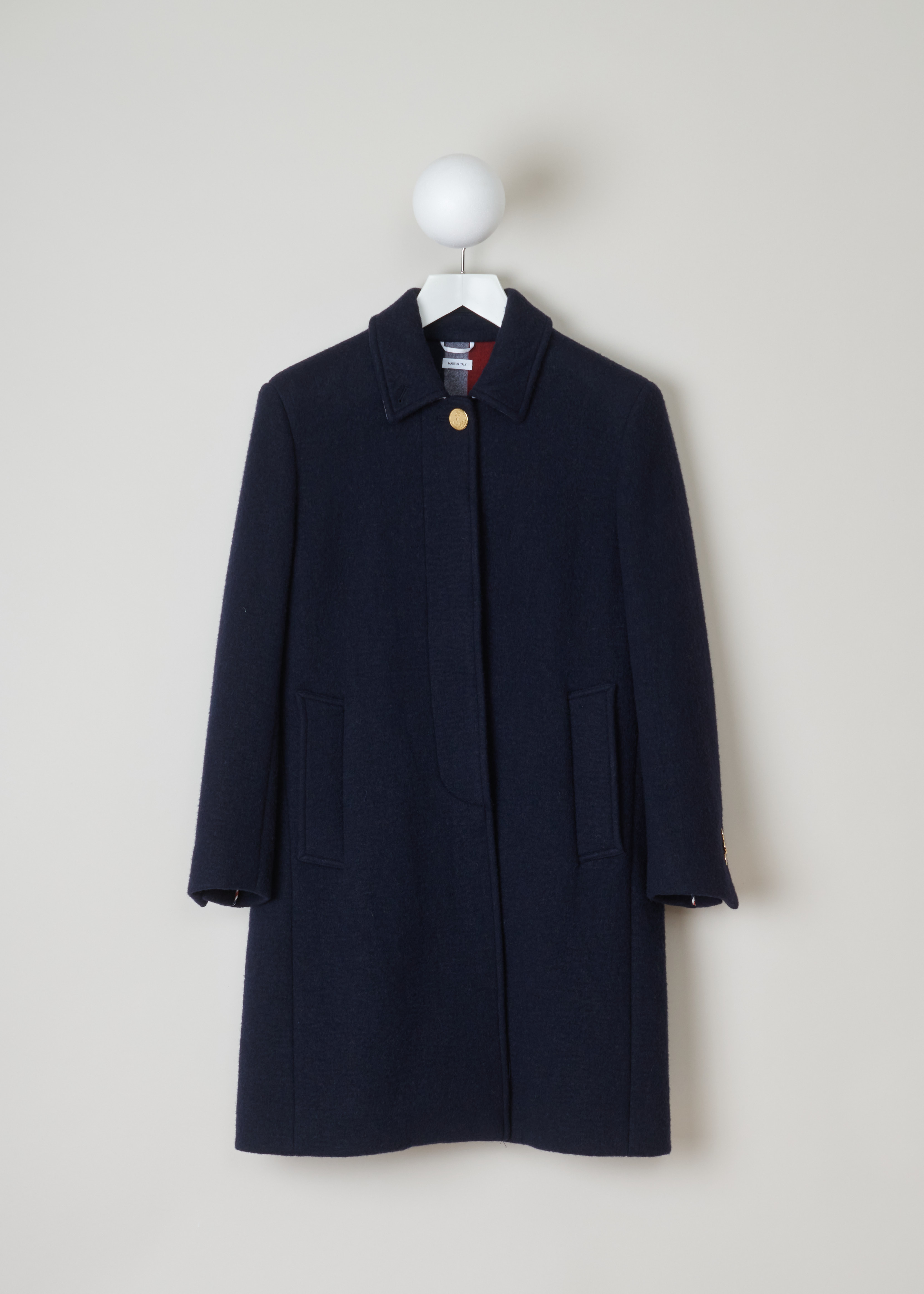 Thom Browne Navy woolen A-line coat FOC411C_03564_415_Navy front. Wool and cashmere blend coat in a classic silhouet with the iconic Thom Browne stripes on the back, a squared collar, concealed button fastening with one visible gold button and two side pockets.