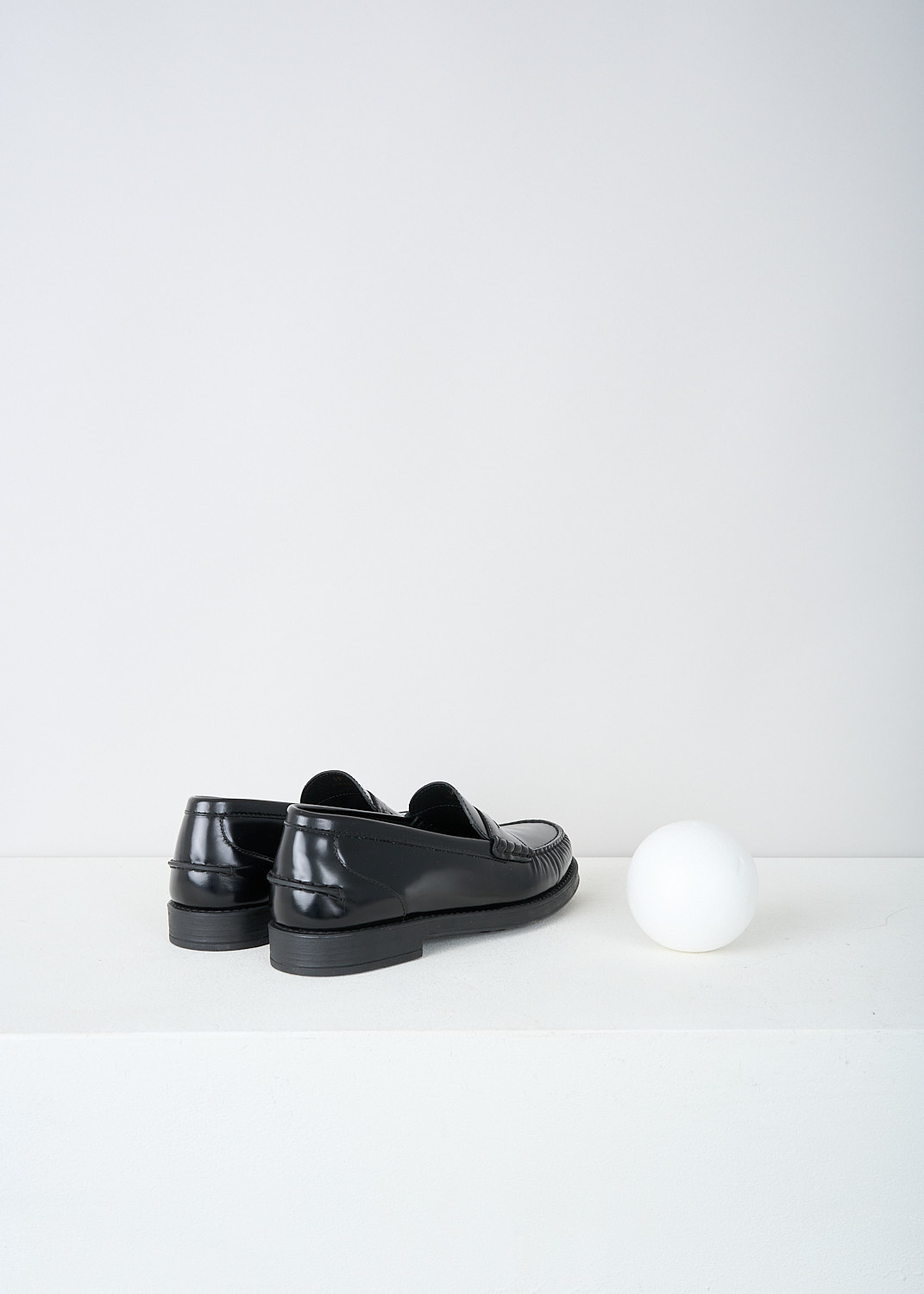 Tods, Black leather penny loafers, XXW02I0EP00SHAB999, Black, Back, These black leather slip-on penny loafers have a rounded toe and a slotted leather strip with a decorative coin over the upper side. Around the trim, the leather is subtly pleated. These loafers have black soles.
  

