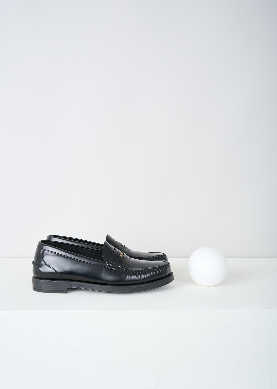 Tods, Black leather penny loafers, XXW02I0EP00SHAB999, Black, Side, These black leather slip-on penny loafers have a rounded toe and a slotted leather strip with a decorative coin over the upper side. Around the trim, the leather is subtly pleated. These loafers have black soles.
  

