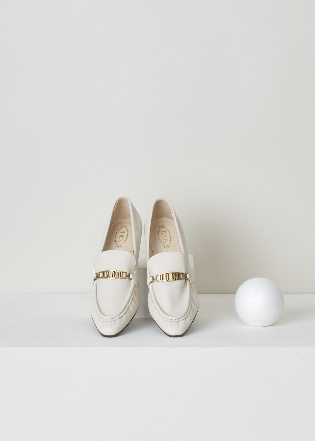TODS, OFF-WHITE LEATHER LOAFERS WITH A TRAPEZOID HEEL, XXW09D0EC80_MID_B015, White, Top, Off-white leather loafers with a wooden trapezoid heel. This model has a pointed toe and a gold-toned buckle decorating the front. Around the trim, the leather is subtly pleated.


Heel height: 6 cm / 2.3 inch. 
