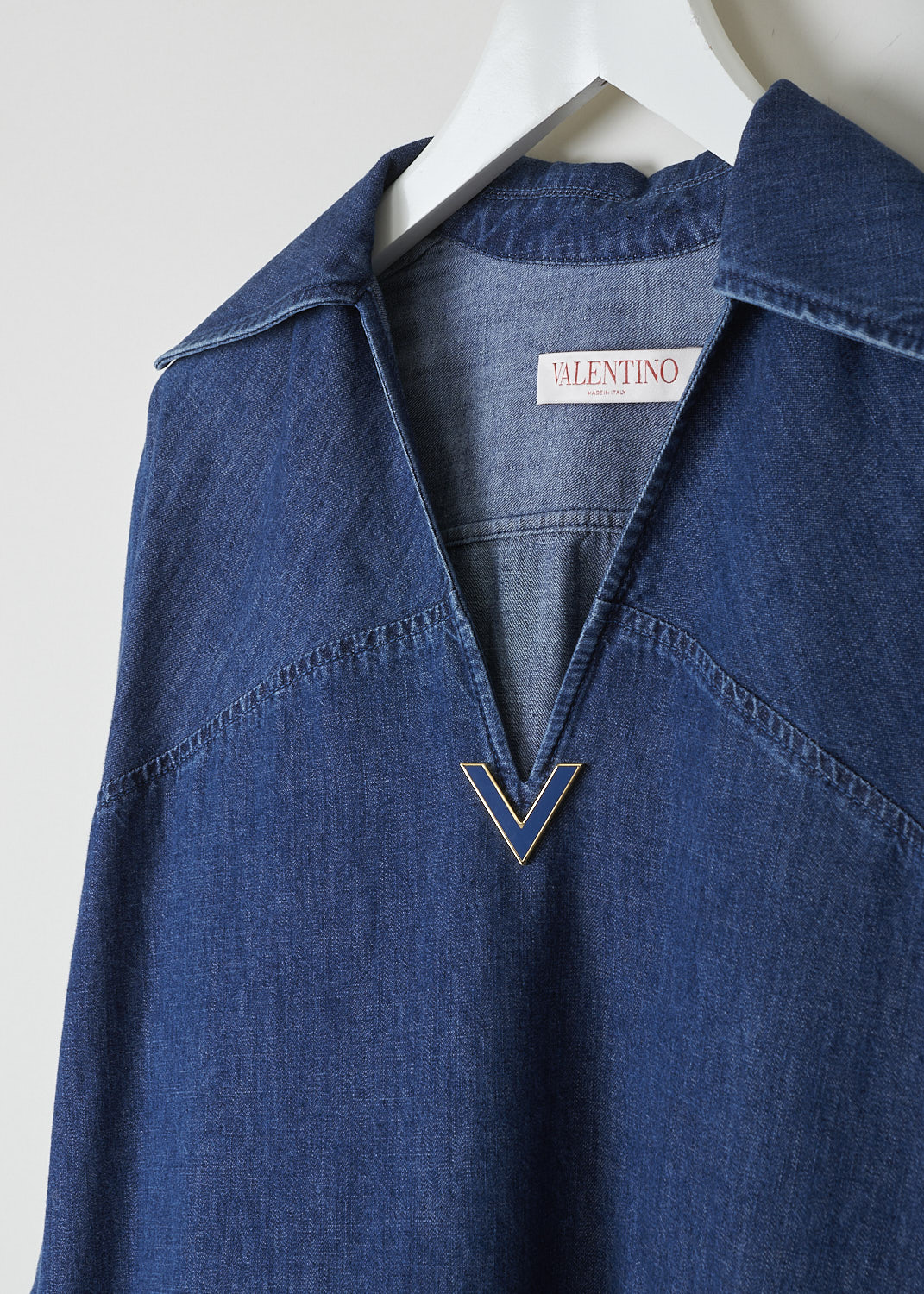 VALENTINO, DARK WASH DENIM TUNIC, XB3DB01I433_558XB3DB01I433_558, Blue, Detail, This wide tunic in a darker wash jean fabric has a spread collar with a V-neckline. The end of the V-neck is decorated with the brands signature V. The tunic has three-quarter raglan sleeves with buttoned cuffs. Slanted pockets can be found concealed in the side seams. The tunic has an asymmetrical finish, meaning the back is a little longer than the front. Small slits can be found on either side. 
