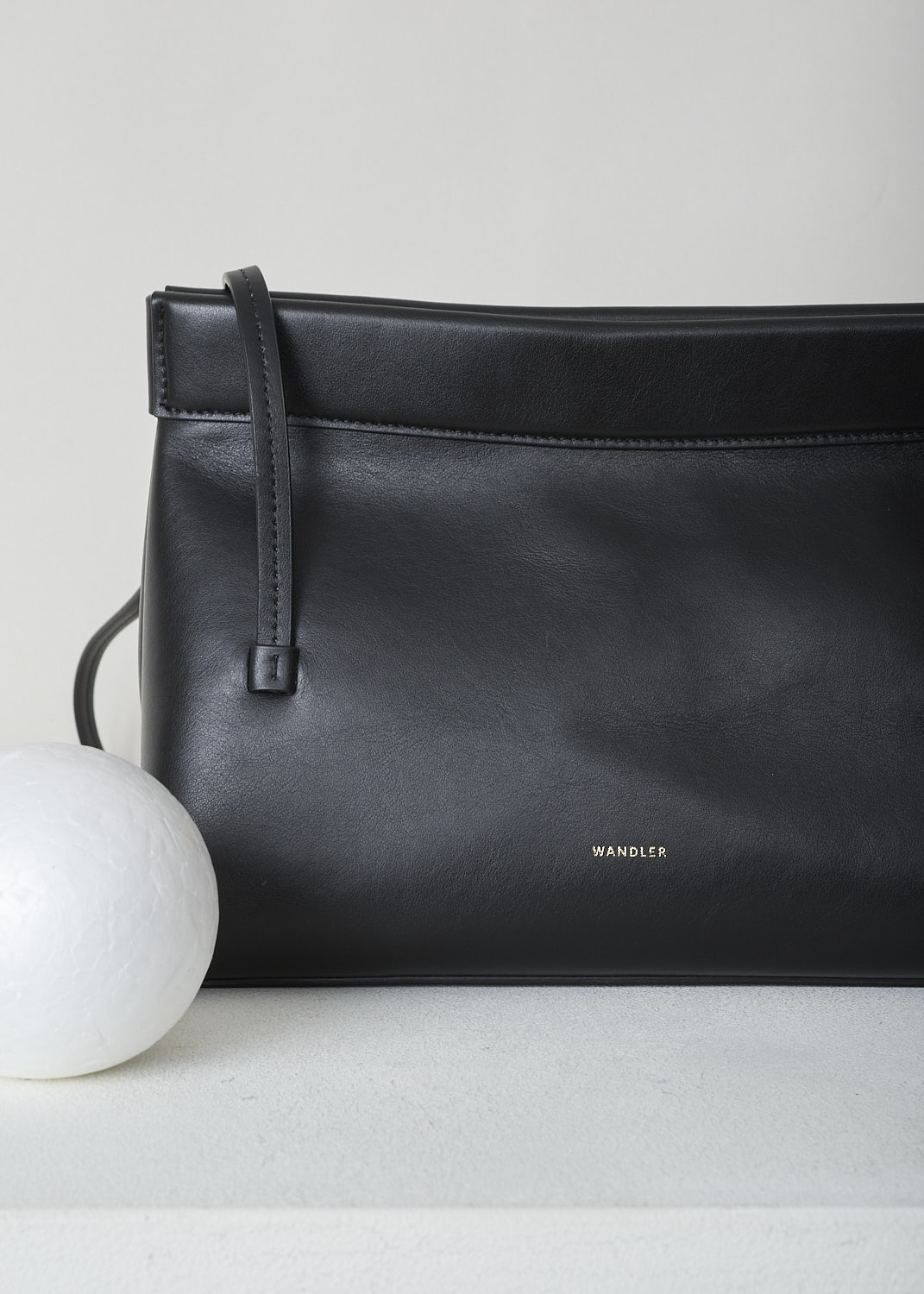 WANDLER, JOANNA MINI BAG IN BLACK, JOANNA_BAG_MINI_BLACK_22108100391, Black, Detail, This black Joanna mini hand bag has slim top handles. The magnetic strip closure opens up to the single spacious compartment. On the front, the brand's lettering can be found in gold.  

